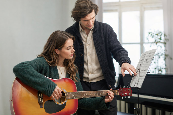 Male teacher and female student in guitar class